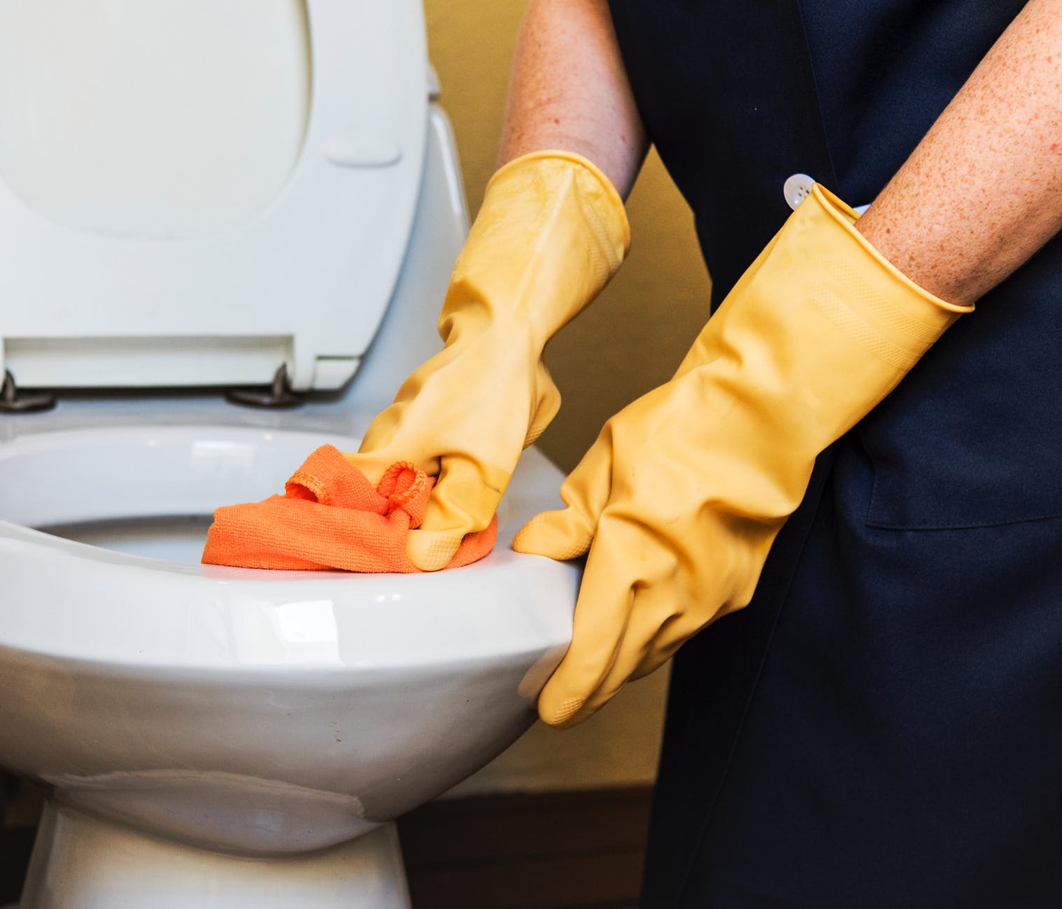 person wearing pair of yellow rubber gloves